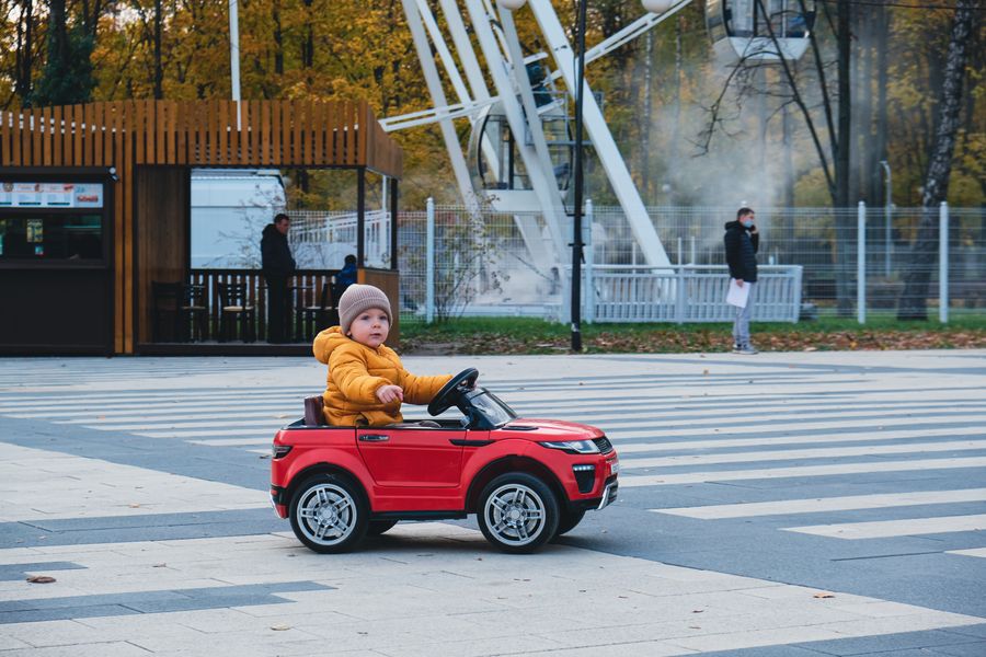 nino coche juguete cruzando calle 2 Niño en coche de juguete cruzando calle