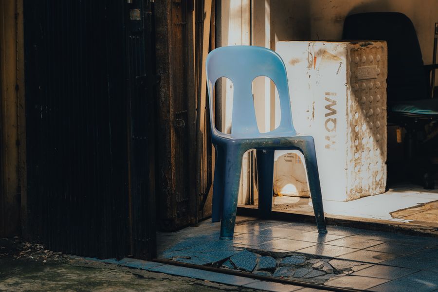 Silla plástica azul en espacio minimalista